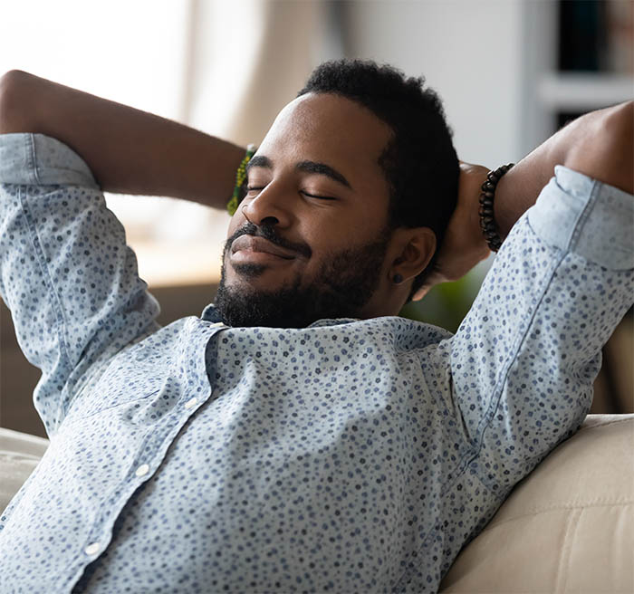 Peaceful carefree biracial guy alone napping on couch indoors.